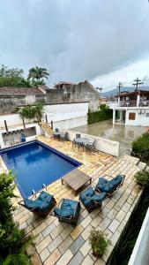 a swimming pool with lounge chairs and a swimming pool at Pousada Angellus in Paraty