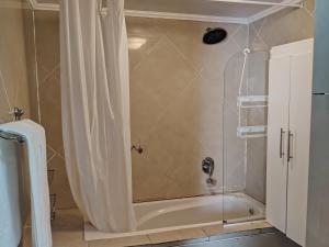 a shower with a shower curtain in a bathroom at Beverly Hills Lodge in Fourways