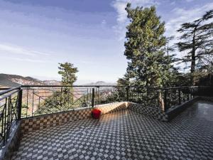 a balcony with a view of the mountains at Nirvana Rooms - Shimla in Shimla