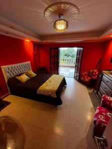 a bedroom with a bed with a red wall at casa cusi in Tafí Viejo