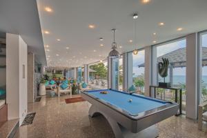 a pool table in a room with windows at Bluesiam Villa - SHA Certified in Surin Beach