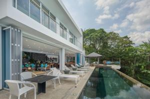 a house with a swimming pool next to a building at Bluesiam Villa - SHA Certified in Surin Beach