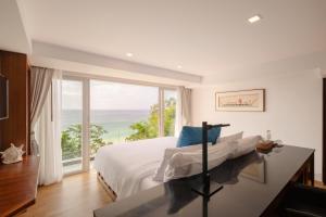 a bedroom with a bed and a large window at Bluesiam Villa - SHA Certified in Surin Beach +66 photos