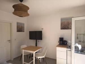 a dining room with a table and a television at Haus Lützowallee in Aurich