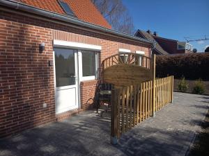 a fence next to a brick building with a white door at Haus Lützowallee in Aurich