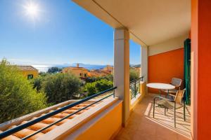 a balcony with a table and chairs and a view at Golden Tiara Apartment in Barbati +7 photos