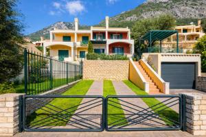 a villa with a gate in front of a house at Golden Tiara Apartment in Barbati