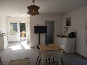 a kitchen and dining room with a table and a television at Haus Lützowallee in Aurich +4 photos