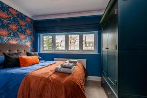 a blue bedroom with a bed with two towels on it at Luxury Beach Escape Pool Table & Private Parking in Broadstairs