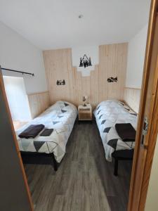 two beds in a room with wooden floors at Cier De Riviere "les Ours" in Cier-de-Rivière