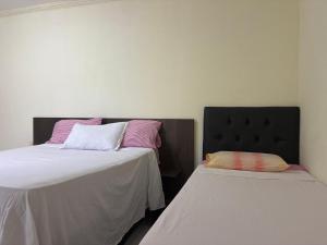 two beds sitting next to each other in a room at Condomínio Il Sole - apartamento 1 in Porto Seguro +2 photos