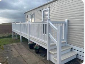 a house with a white railing and stairs at AJL Caravan Rentals in Turnberry