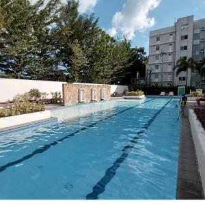a swimming pool with blue water in a building at Nanay's Condotel in Sampong