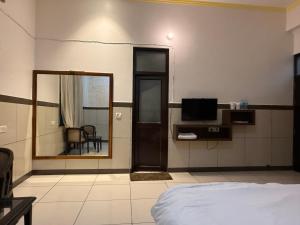 a bedroom with a bed and a mirror and a television at Primrose Hotel in Murthal +25 photos