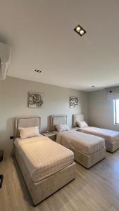 a room with two beds and a couch at شالية موج 335 in Dhahran
