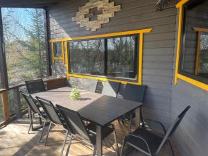 a table and chairs on a screened in porch at Feniksiukas in Agluonėnai
