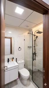 a bathroom with a shower and a toilet and a sink at Jawharat Tetouan in Souani