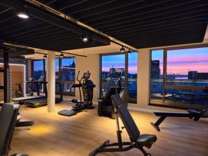 a gym with cardio equipment in a building with a view at ScanHotels Stadthafen in Rostock