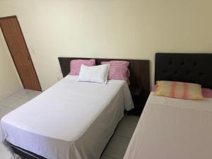 two beds sitting next to each other in a room at Condomínio Il Sole - apartamento 1 in Porto Seguro
