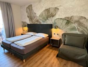 a bedroom with a bed and a chair at Hotel Alesi in Malcesine