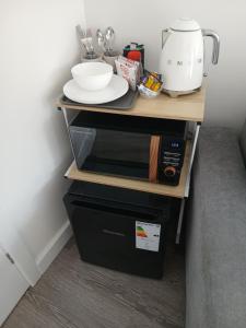 a kitchen with a table with plates and a blender at Moodyscroft Homestay, NEC, BHX, Resorts world, HS2, JLR - Netflix in Birmingham