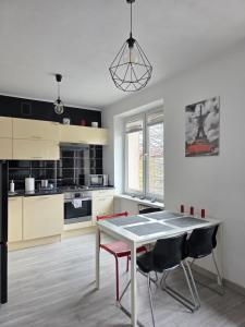 a kitchen with a table and chairs in a room at GreatLoft Apartament in Oświęcim