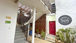 a building with a red door and a sign on it at HOTEL SOÍ BACALAR in Bacalar