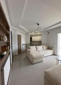 a white living room with a couch and a table at Apartment with sea view and pool access in Chott Meriem