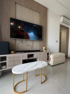 a living room with a tv on a wall at Apartment with sea view and pool access in Chott Meriem