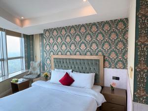 a bedroom with a large white bed with red pillows at Hotel White Castle Islamabad in Islamabad