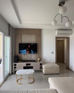 a living room with a tv and a couch at Apartment with sea view and pool access in Chott Meriem