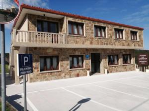 a building with a parking sign in front of it at Fragas da Canteira Hotel Rural in Lires