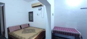 a small room with a bench and a heater at Uthamar Illam in Tiruchirappalli