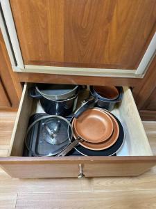a drawer full of pots and pans in a cabinet at Wilderness Retreat in Alba