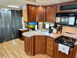 a kitchen in an rv with wooden cabinets at Wilderness Retreat in Alba