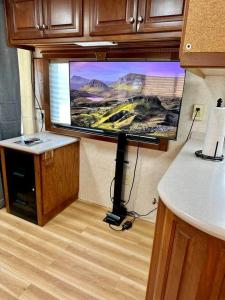 a large flat screen tv in a room with a kitchen at Wilderness Retreat in Alba +14 photos