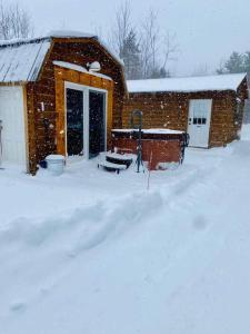 a house covered in snow in front of a building at The Buck Shack in Elmira