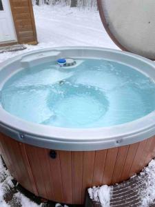 a jacuzzi tub with blue water in the snow at The Buck Shack in Elmira
