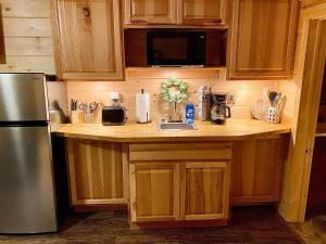 a kitchen with wooden cabinets and a stainless steel refrigerator at The Buck Shack in Elmira