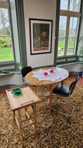 a living room with a table and two chairs at Pastorie Tijdverblijf in Zuidhorn +18 photos