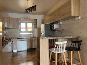 a kitchen with a counter and two bar stools at Villa Al-Qamar in Midoun