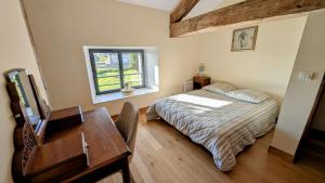 a bedroom with a bed and a desk and a table at Belle vue in Dournazac +24 photos