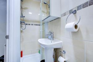 a white bathroom with a sink and a shower at Hampstead Residence Hotel in London