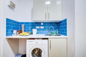 a kitchen with a washing machine and a sink at Hampstead Residence Hotel in London
