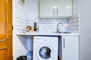 a kitchen with a washing machine and a sink at Hampstead Residence Hotel in London