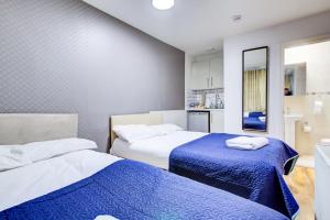 a bedroom with two beds and a kitchen at Hampstead Residence Hotel in London +23 photos