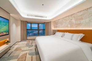 a bedroom with a large bed and a tv at Argyle Waifiden Hotel in Guangzhou