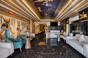 a lobby with couches and tables and a television at Superior Pyramids View in Cairo