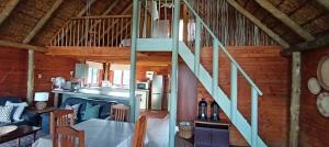 a living room with a staircase in a cabin at Vaalkop Dam Reserve Log Cabin, Self-Catering, Beestekraal in Beestekraal