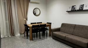 a dining room table with black chairs and a couch at Black Daisy in Bernalda +3 photos
